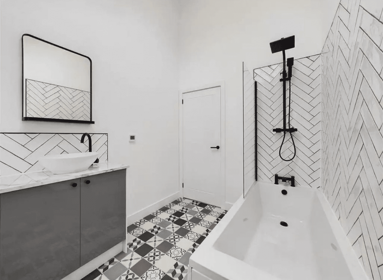 Luxury bathroom with herringbone tiles and freestanding bath