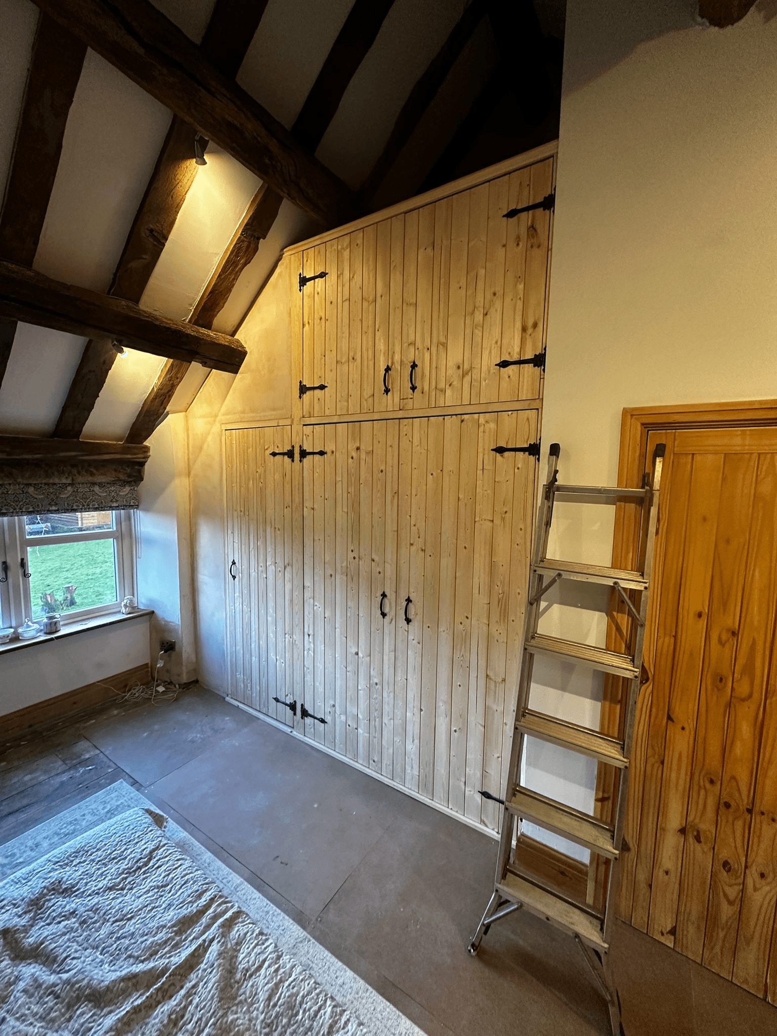 Fitted attic cupboards with exposed timber beams